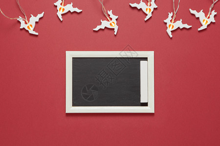 圣诞园形式为白跑鹿小粉笔板在暗红背景上有复制空间用于明信片版式布局新年概念横向平淡最小极简主义者季节图片