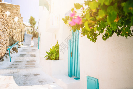 乐趣街道循环的在希腊穿白色衣服的女孩在Mykonos街上玩的户外游乐女孩在Mykonos街上的典型希腊传统村庄街上有白色的墙壁和图片