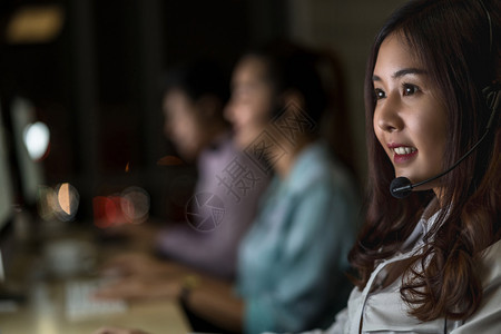 耳机沮丧的助手亚洲女客户护理服务的肖像在办公室呼叫中心部门工人和加班部与同事一起为成功而团队工作商务人员在办公室工人和超时作上夜图片