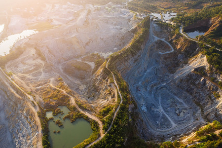 在森林起重机和生产花岗岩大理石矿场建筑设备之间的花岗岩采石场上空飞行造成气污染巨石采矿业Granite采矿业无人机材料建造背景图片