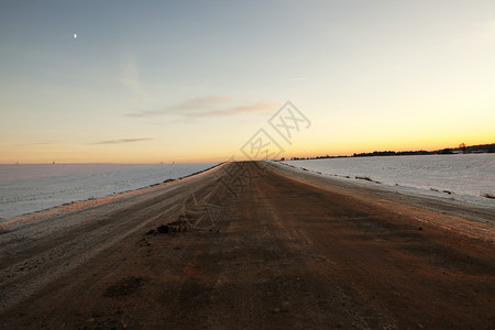 灾难户外超过道路上有很多泥土和地在一片雪覆盖的道路上被融雪压碎了的泥土和地一条铺着雪的公路上发生暴风雪图片