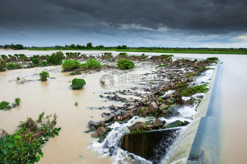 堰TonleSapRiver水坝漏道在雨季溢出暴风即将到来柬埔寨的洪泛平原柬埔寨金边多云的三角洲图片