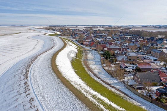 从弗里斯兰的Moddergerat雪地村起飞冬季在荷兰一个冰冻的瓦登海圣诞节阳光泥图片