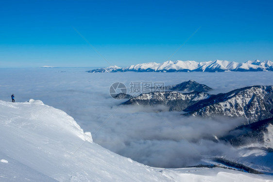 风景蓝色天空和雪峰上阳光明媚的天气山谷是浓雾孤独的旅游者拍摄着美丽的白花峰和峡谷中的雾游客最佳图片