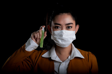 防毒面具手用塑料瓶或抗细菌的酒精喷洒防止黑本菌种传播她们戴着呼吸