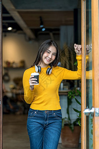 曼谷亚裔年轻女在现代咖啡店或工作间与咖啡机生活方式和休闲以及业余爱好和企家概念并列的咖啡店或合用空间一起喝咖啡快乐的现代图片