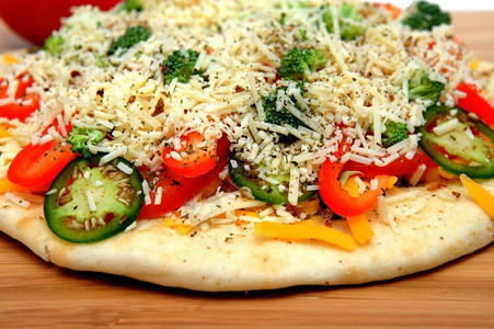 奶酪美食酱准备进入烤炉的蔬菜披萨里面塞满了尖利切达和亚洲芝士新鲜西红柿铃椒辣花椰菜和干草药图片