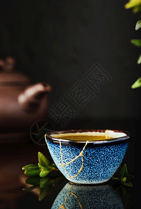 自然深色背景中的日本绿茶杯有选择地关注杯子回收陶瓷蓝杯事物的第二生命回收或kintsugi青菜美食图片