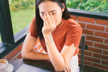 在笔记本电脑上工作的女商人头痛情不感应的面部表情觉成人公司城市图片