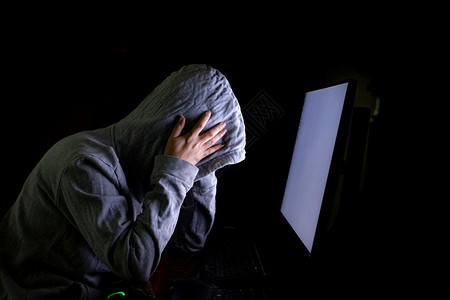 笔记本和女黑客男人隐私女黑客闯入数据服务器在其藏身处感染系统有深蓝色的氛围女士戴上双轨码背景笔记本电脑马拉威概念Malware恶意软件背景