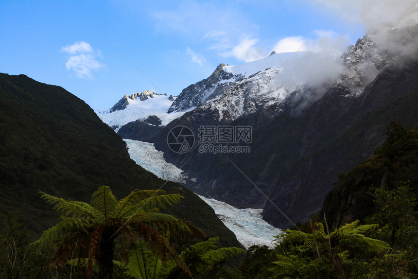 置换衰退明亮的冰川和高山前棕榈树林蓝天的色空图片