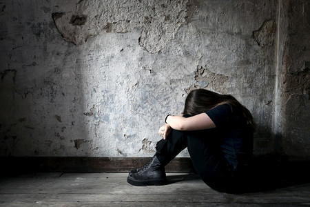 悲伤孤独无助抑郁迷茫悲惨的恐怖沮丧和孤独的女孩自坐在木地板上一个