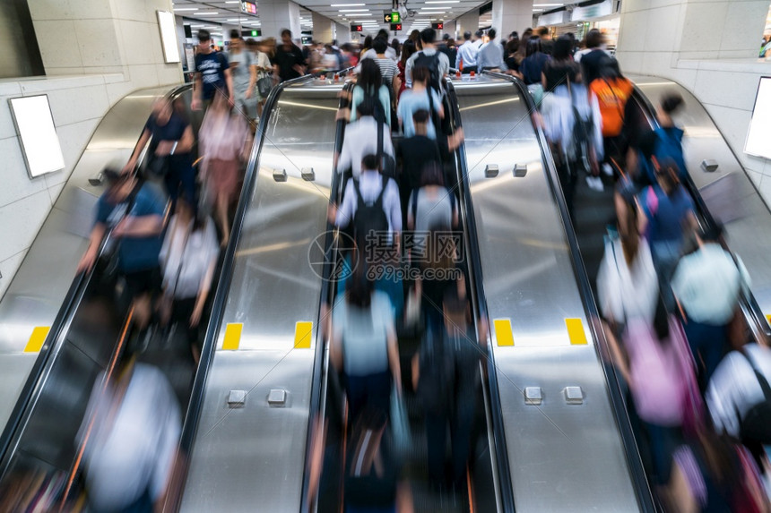 洪紧迫在央区香港地铁交通中心快速移动和商人概念工作之前清晨在高峰时钟的扶梯上行走然后乘地铁交通中心香港区快速移动和商业人员概念图片