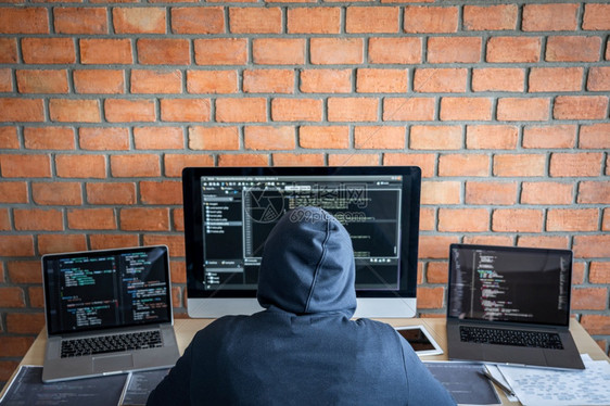 编码联网危险戴头罩的黑客使用多个计算机将坏数据输入在线系统并携带来感染窃取信息IfterHebcackhacker或网络攻击概念图片