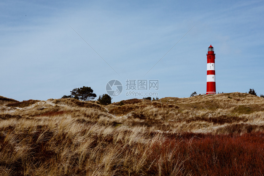 全景沙丘山上红色灯塔的图景观与云层天空相距遥远从低角度看浅地土草干德国阿姆鲁石勒苏益格荷尔斯泰因松弛图片