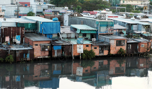 场景城市HOCHIMINHCityVietNANSNNOV2107年河滨居民在晚上雨后住一组临时房从金属板或红砖下降为临时住房靠图片