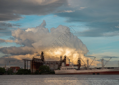 工厂日落烟囱泰国曼谷201年7月日一艘货船停在ChaoPhraya河石油炼厂前面晚上图片