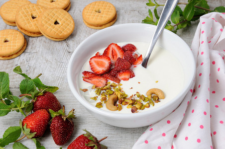 来自希腊酸奶的冷冻黄油牛汤配有草莓和松果腰脆饼干垂直拍摄蔬菜开心果清爽图片