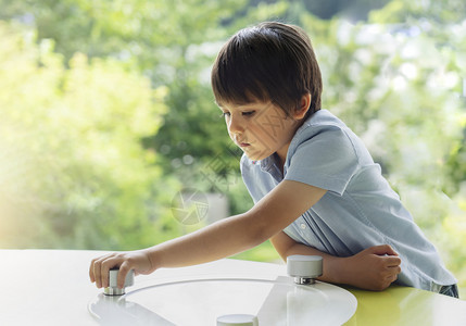 孩子们杰米桌学校小孩在游戏室玩的高度关键肖像其自然背景模糊不清儿童持着底层游戏在窗边阳光明媚的房间里长着好奇脸孔学习和玩耍教育概图片