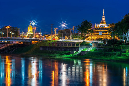 暮快乐的丰富多彩Naresuan桥上的NanRiver灯和WatRatchaburana的Chedi和PrangPhraSiRa图片