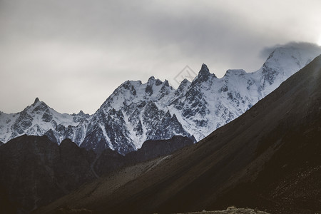 巴基斯坦GojalHunzaGilgitBaltistan卡拉科姆山脉风雾高的峰中黄昏雪顶群山壁上帕苏日落的美丽景色农村吉尔特太图片