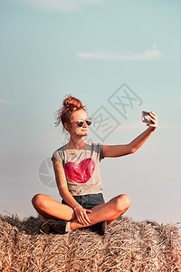 少女自拍坐在干草地上享受乡村的Candid人暑假真实的时刻情况Y我包场地手机图片