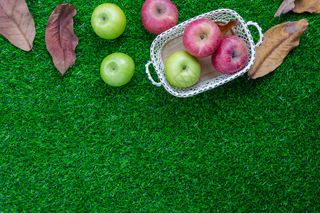 农场甜的仪式在表顶上查看装饰瀑布收获季节或RoshHashhanah白天背景概念的空中图像Flat将绿色红苹果放入木篮在生锈草丛图片