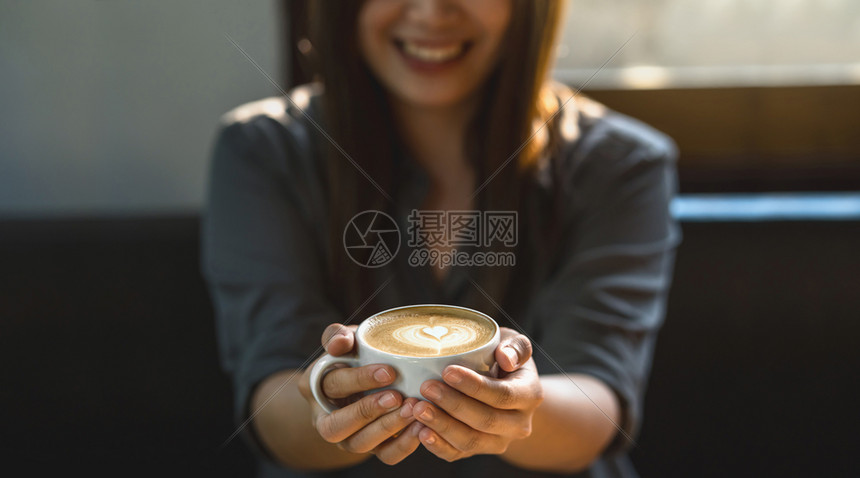 艺术杯子亚洲年轻女在现代咖啡店或工作空间窗户镜子生活方式和休闲以及业余爱好和企家概念横幅或网络封面规模之外在现代咖啡店或合用办公图片