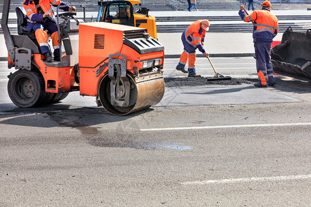 蒸汽道路服务人员使用振动压路机道推土和金属水平仪修复路面和压实沥青振动溜冰场和道路推土机等小型道路设备积极用于修补道路铺设施工图片