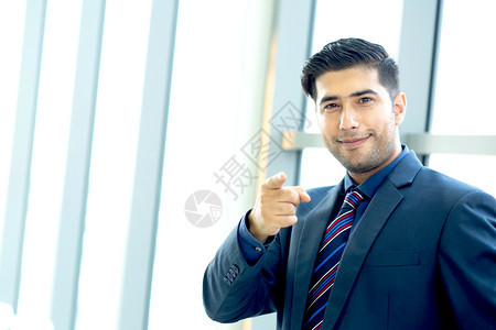 充满欢乐的商人样板穿着微笑装的样子在镜头上举起拇指展示与办公室背景相比的成功经验请留下写描述文字的复制空间灰色的写作瓜拉纳皮图片