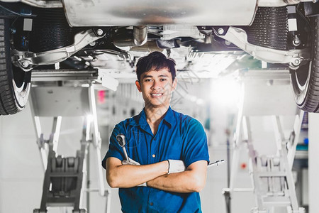 车辆压力维修服务中心保养的汽车下面有修理设备是供客户使用的展示室技术员或工程师专业作的一部分亚洲机械工的肖像维修设备处于服务中心图片