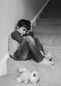 情感悲伤的男孩子坐在楼梯的角落里精神健康心理痛情绪压抑的男孩子正坐在楼梯的拐角上校对PortnoyHigh地毯郁闷图片