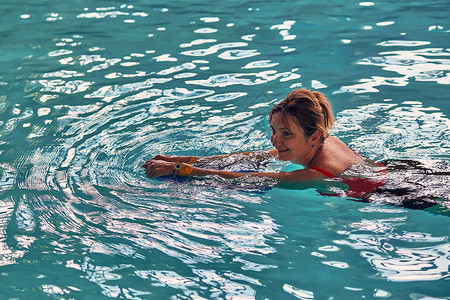 溅刷新青少年女人学习游泳在池里练习使用董事会的Candid人真正的瞬间实情况图片