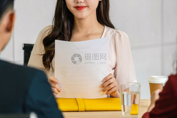 交易年轻亚洲女毕业生持有简历文件并准备接受两名经理然后开始面试工作在会议室提出积极动企业雇用新会员概念BusinessHirin图片