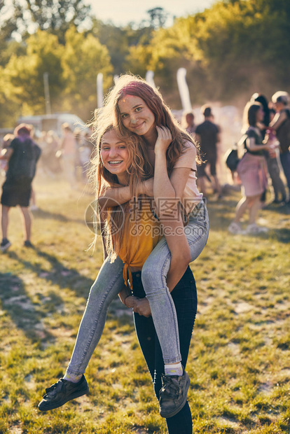 女孩们文化笑的年轻女孩肖像脸上和衣服涂着彩色料两个朋友花时间在辣椒颜色节上图片