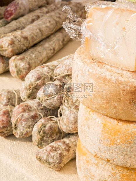 黄色的圆形销售在当地市场上出售的桌布四环包装奶酪和一群沙拉米芝士图片