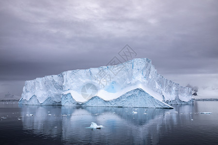 白色的大型冰山周围美丽的照明状况海面上漂浮着一个广场海洋冷冻图片