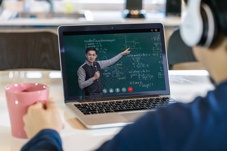 互联网通过视频电话会议与老师一起学习亚洲生对黑板上ThaiLaguage的物理公式学看法Covid19大流行病教育及社会失常概念图片