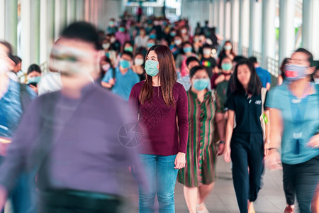 身戴外科面具以防止在曼谷交通的高峰工时作日出现冠状暴发事件在曼谷交通车厢中行走和站在人群中间的亚洲妇女她们身着外科面具穿处模糊无图片