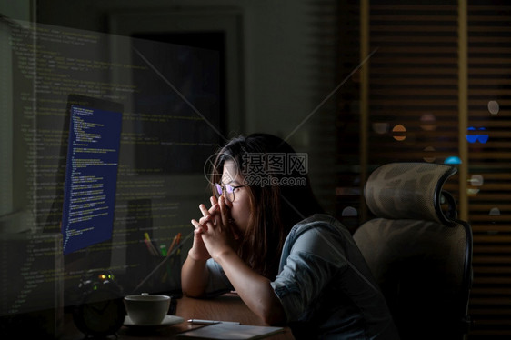 女士亚洲商人在计算机桌面前辛勤工作编程源代码和电脑屏幕上运动图像的编程源码晚间以令人振奋而严肃的行动在工作场所技术监视器图片