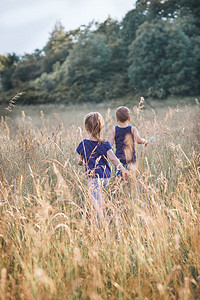 快乐的小孩在乡下高草地上玩耍真正的瞬间实现环境营火积极的女图片