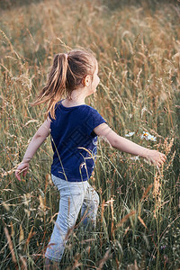 快乐的小女孩走过乡下高草地坎迪德人真实的时刻情况在真正的瞬间假期娱乐图片
