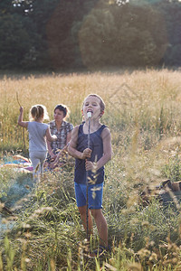 场地男孩在野火中烤了棉花糖后吃在草地的坎迪德人身上真实的时刻情况坦率男人图片