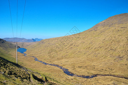 户外美丽的山区地形景观包括层饼山河谷韦斯特曼纳雨水收集大坝和法罗群岛StreymoyStromo岛的输电线路法罗群岛光荣地貌的法图片