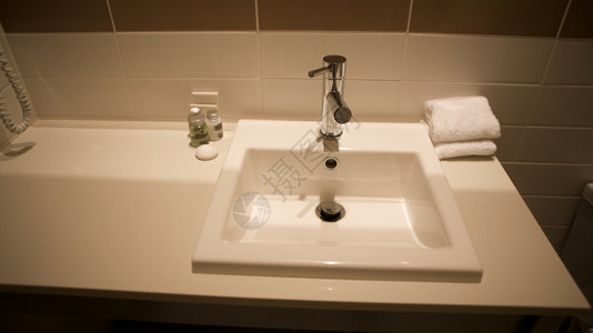 与洗涤盆地家旅馆有关的浴室与洗盆地房或酒店相关间的浴室水汪湿图片