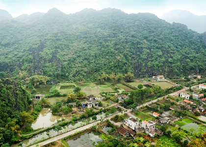 亚洲清晨雨天越南新平NinhBinh旅行地貌和目的背景对稻田石灰岩和山顶HangMua庙寺的山顶塔进行惊人的全景观强调人图片