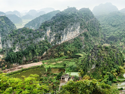 老的早期克什米尔清晨雨天越南新平NinhBinh旅行地貌和目的背景对稻田石灰岩和山顶HangMua庙寺的山顶塔进行惊人的全景观图片