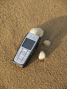 沙滩上的手机细胞贝壳闲暇海滩电话休息背景图片