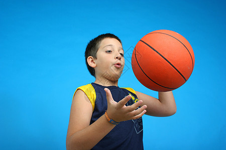男孩打篮球 蓝背景孩子们分数力量成功工作室比赛乐趣冠军衣服运动员图片