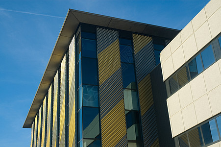办公大楼建筑黄色玻璃角落灰色蓝色商业天空窗户高楼背景图片